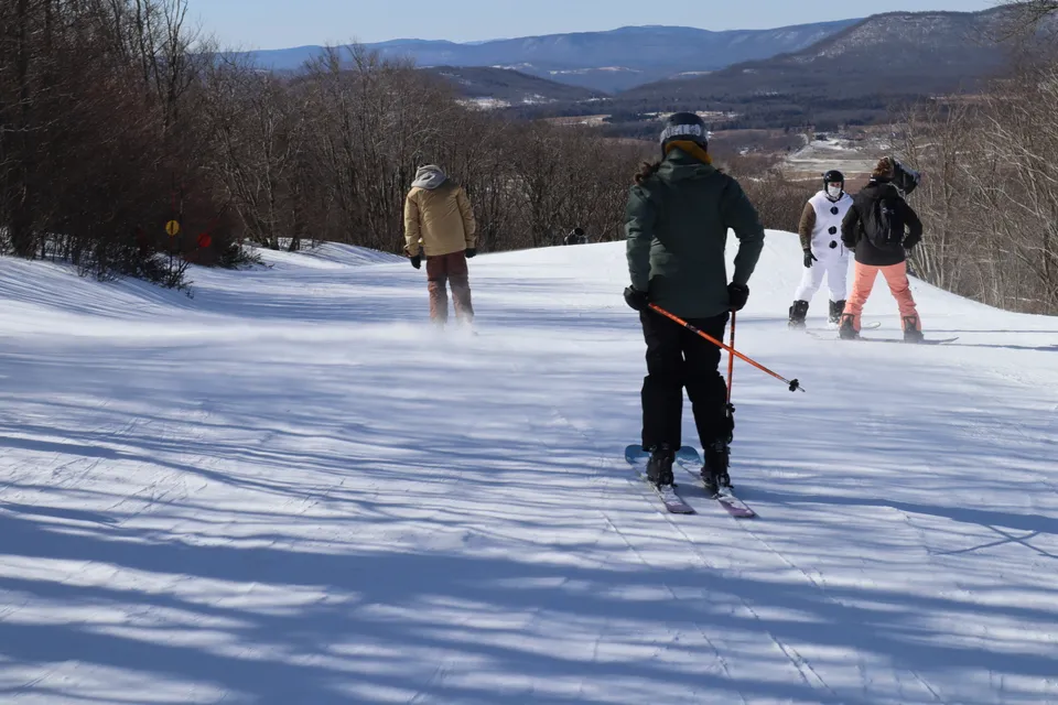 students skiing down a snowy mountain slope