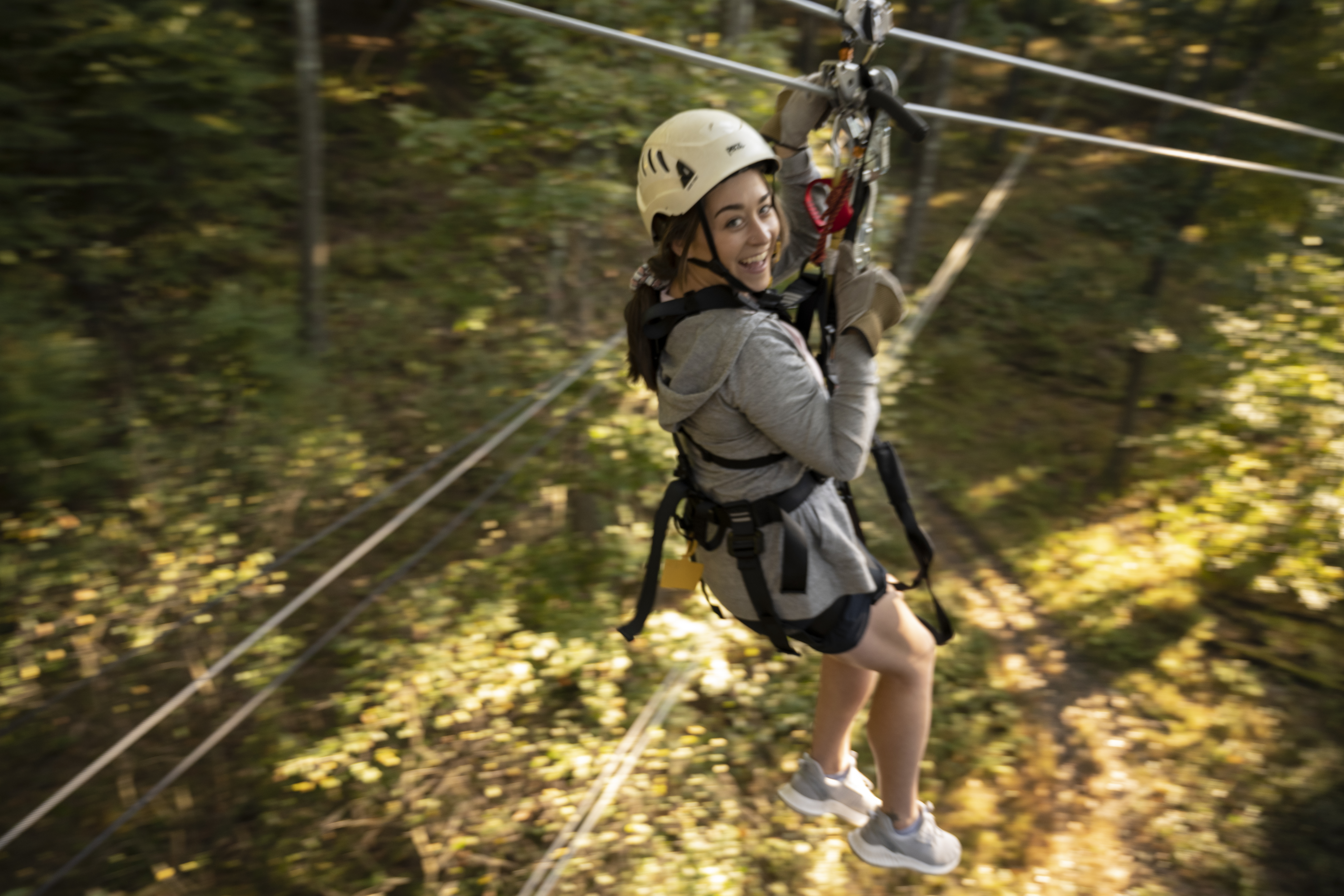 girl on zipline through forest